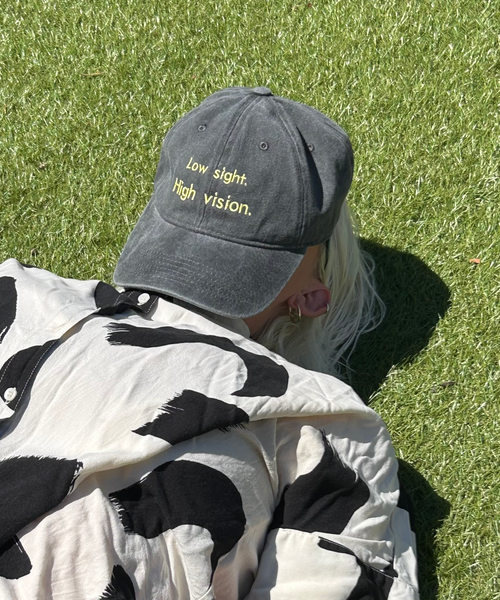 Black and yellow low sight high vision cap on someone laying down propped on face