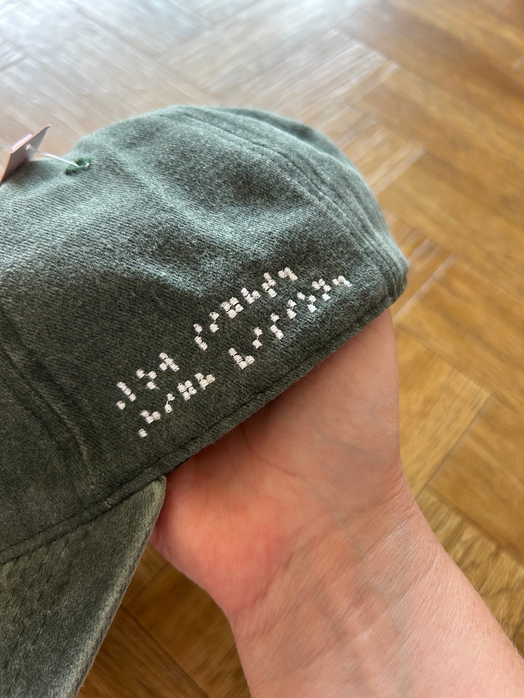 Low sight. High vision. Washed cotton cap in green / black with white embroidery