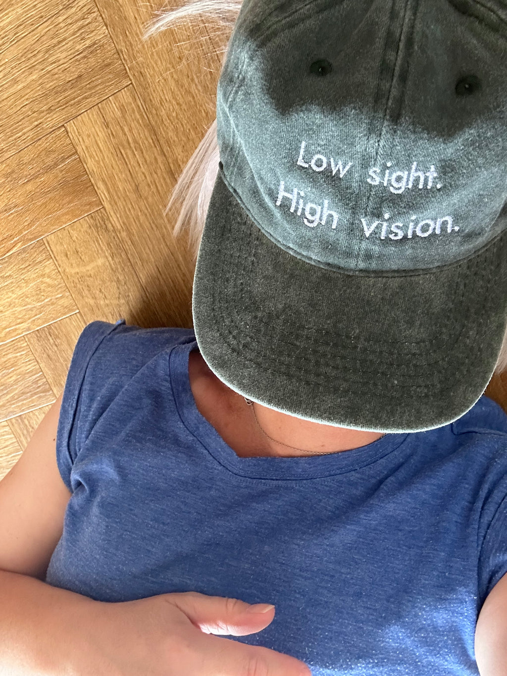 Low sight. High vision. Washed cotton cap in green / black with white embroidery