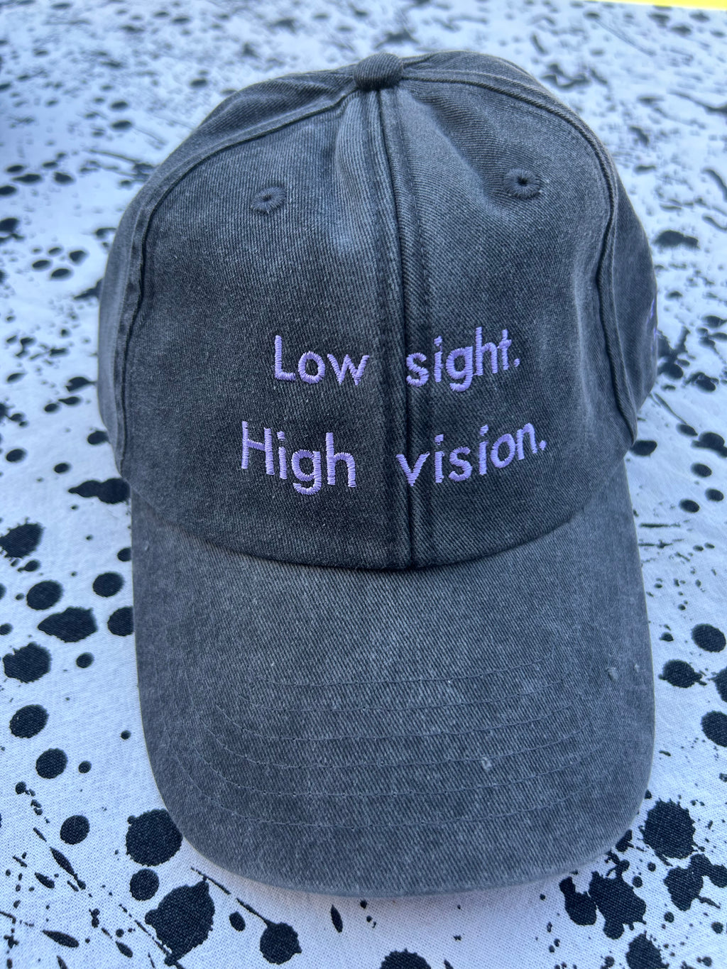 Low sight. High vision. Black and lavender 100% cotton cap.