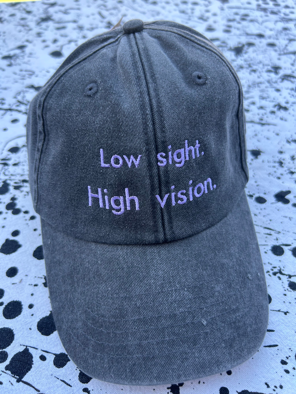 Low sight. High vision. Black and lavender 100% cotton cap.