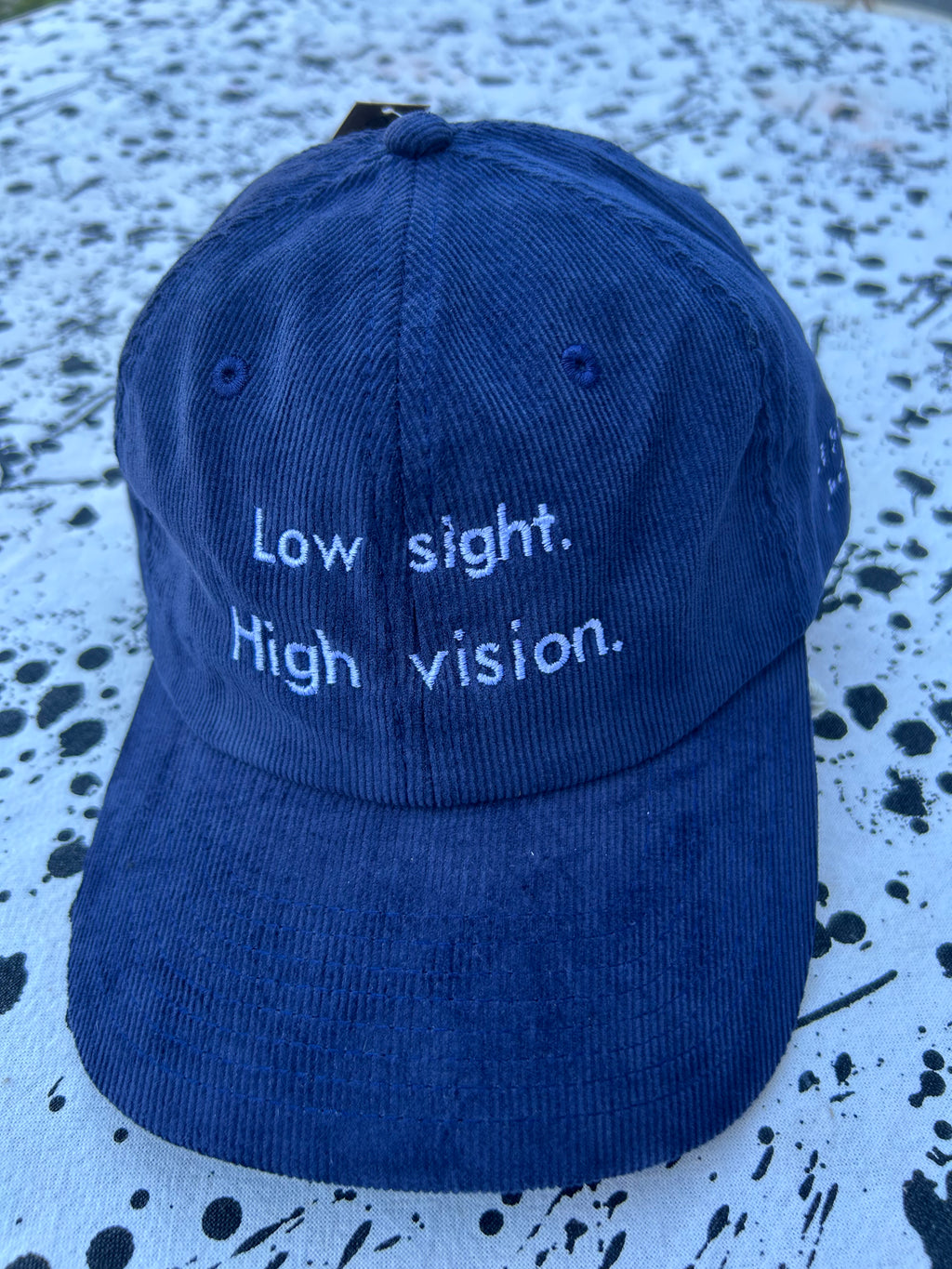 Low sight. High vision.  Navy cord 100% cotton cap with white embroidery