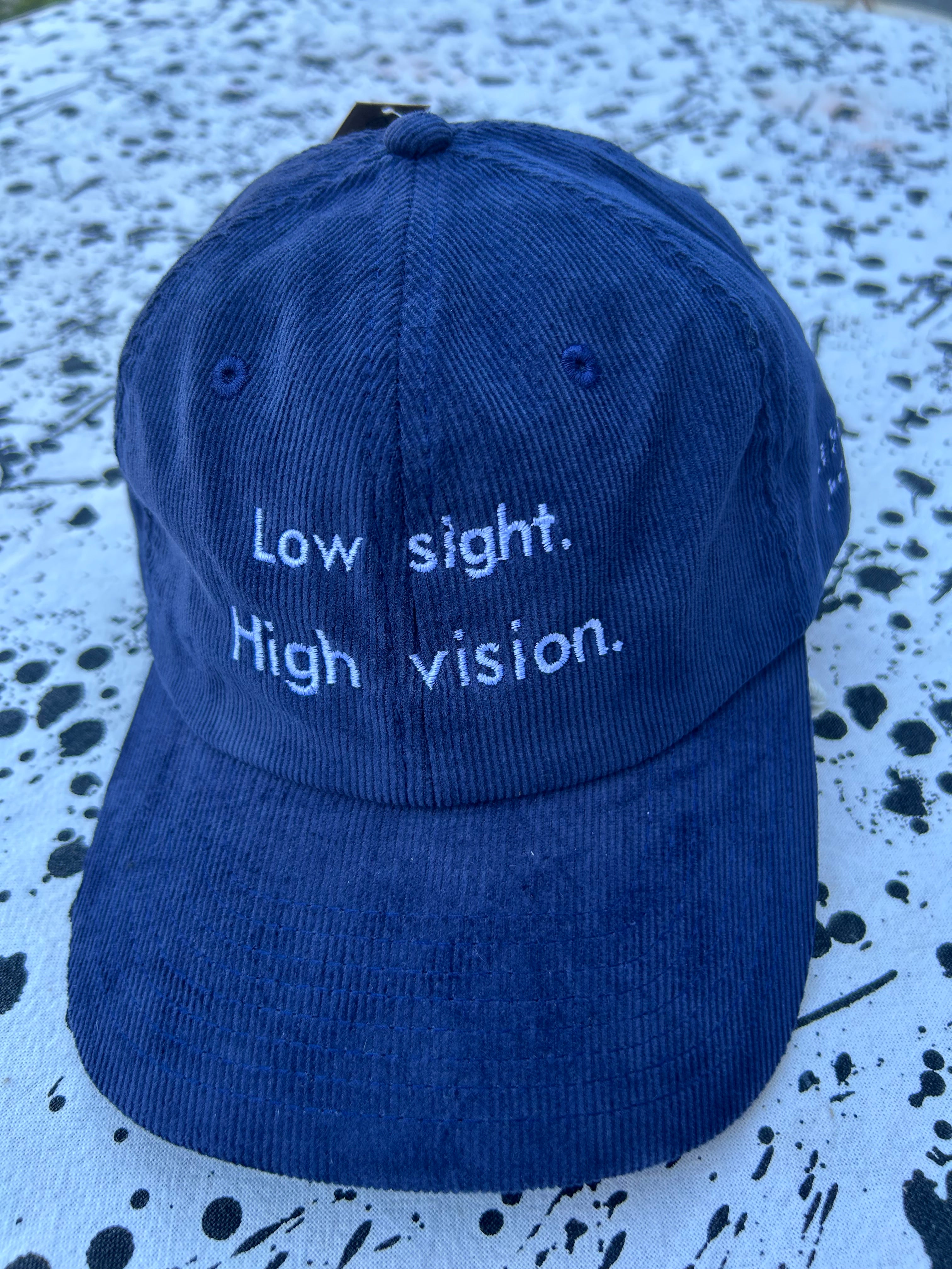 Low sight. High vision.  Navy cord 100% cotton cap with white embroidery